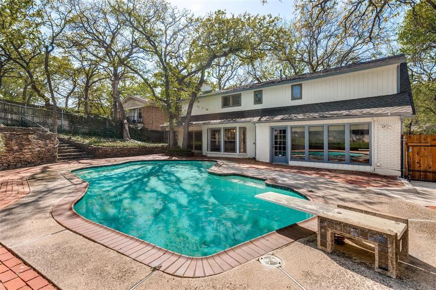 Discover timeless charm and modern comfort in this beautiful brick home set on a treed lot with a sparkling pool and inviting outdoor spaces. Thoughtfully landscaped front yard and courtyard create picture-perfect curb appeal before you even step inside. The warm and welcoming living room features classic wood beams, a cozy fireplace with a stone hearth, and custom built-ins—an ideal space for gathering. The eat-in kitchen is designed for both everyday living and entertaining, offering granite countertops, a kitchen island, and double ovens. Enjoy additional spaces in the formal sitting room and dining room, perfect for hosting holidays and special occasions. A large flex space with built-ins provides endless possibilities—media room, playroom, home office, or creative studio. The downstairs mother-in-law suite—complete with a cedar closet—is perfect for guests or multigenerational living. Upstairs, the primary suite features an ensuite bath with dual sinks and a private balcony overlooking the front yard. Two additional bedrooms and a full bathroom complete the upper level. Enjoy the quality and energy efficiency of Pella windows installed throughout the home, as well as fresh paint and carpet. Step outside to your own private retreat: a beautifully landscaped yard with a stunning pool, room for a garden, and plenty of space to relax. An attached grill connected to the home’s natural gas line makes outdoor cooking effortless. This home offers space, charm, and flexibility both inside and out—ready to welcome its next owners! Foundation repairs done 2026 with foundation's lifetime transferable warranty and new pipes.