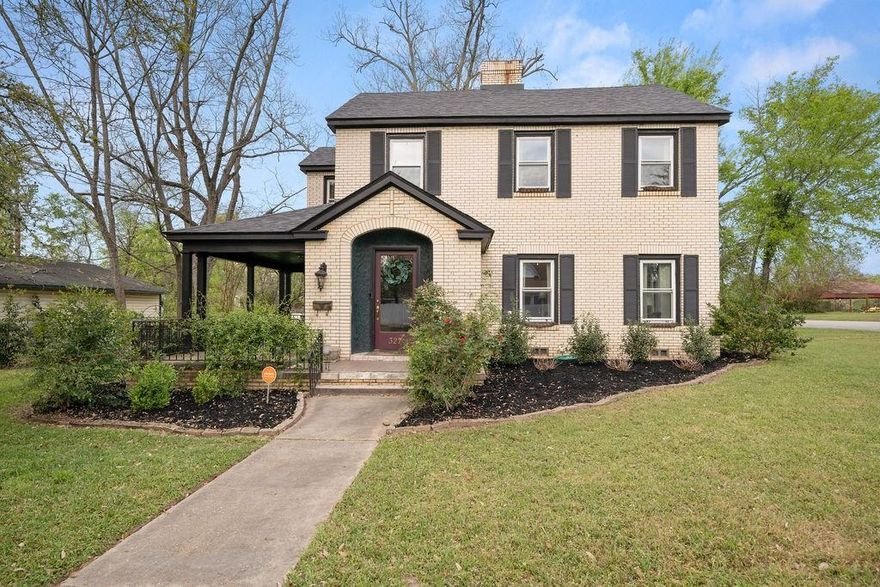 Welcome to this charming brick Tudor style home, full of character and timeless appeal, perfectly positioned on a prominent corner lot in Troup, TX. Offering 4 bedrooms, 3 full baths, a formal dining room, and a dedicated office, this spacious residence blends classic architecture with everyday functionality! Step inside to a warm and inviting parlor featuring a centered fireplace, elegant beam work, and beautifully refinished original hardwood floors that carry throughout the home. The parlor flows seamlessly into a large formal dining room highlighted by a beadboard ceiling, statement chandelier, and French doors, creating an ideal setting for hosting. Just off the main living area, a richly appointed study offers stained oak paneling, built in bookcases, a brick fireplace, and its own private exterior entrance, making it perfect for a home office or business space. The kitchen is well equipped with a gas cooktop, double ovens, a large center island, and abundant cabinetry, providing both function and storage. One of the most inviting spaces in the home is the sunroom, filled with natural light from six large windows and offering peaceful views of the backyard. Upstairs, you’ll find an oversized primary suite with a private en suite bath, along with three additional bedrooms, all generously sized. Outside, the backyard offers a serene retreat with a patio and covered pavilion, perfect for relaxing or entertaining. A spacious detached two car garage completes the property. This is a rare opportunity to own a true piece of character-rich architecture in Troup. Schedule your showing today!