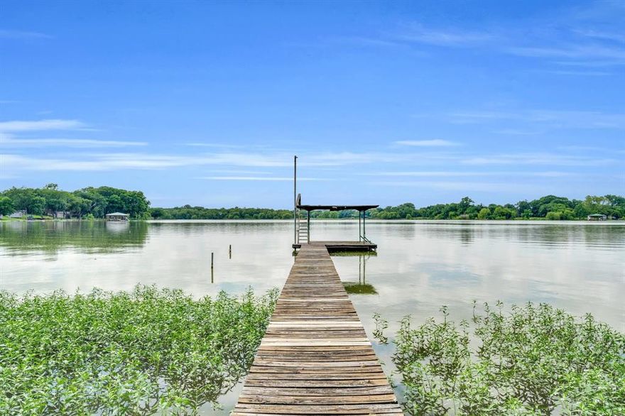 RARE OPPORTUNITY to purchase a lakefront property on Lake Waxahachie! This cozy retreat has been recently updated and even contains a loft in one of the bedrooms. Additionally, there is a 420 square foot bunkhouse for extra space. The large private dock is ideal for fishing, swimming, or boating. The backyard is fully fenced and has several towering trees, providing the perfect amount of shade and privacy. Don't forget to enjoy the large, stone fire pit under the evening stars and a cool lake breeze. The slope of the backyard works perfectly for water slides and other fun outdoor activities! New aerobic septic system and new roof installed. The perfect location: A rural, low trafficked, and quiet neighborhood only minutes from 77 & I35. Furnishings are negotiable, making this lakefront gem move-in ready - perfect for weekend getaways or enjoying lake life year-round. MUST SEE IN PERSON, pictures just can't capture the full beauty!