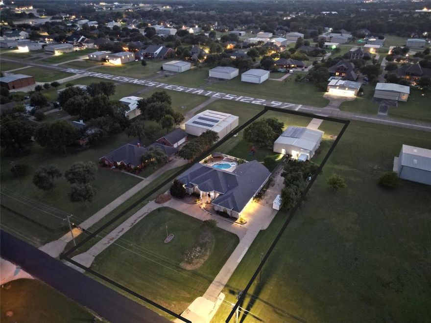 Discover the perfect blend of comfortable living and aviation lifestyle in this hard to find airpark home located on the runway within the Eagle's Nest airport community near Midlothian. Located on a 1.38 acre runway lot. Ideal for aviation enthusiasts or those seeking ample space , this home boasts a functional floorplan with an updated kitchen. Split floorplan with a dedicated media room, office, and a VERY spacious owner's retreat and an oversized 3 car garage. Private backyard  featuring an inground pool and a covered outdoor living area. 50x64 airplane hangar with a workshop and a 43x11 bifold airplane door with room for all the toys including RVs, boats, car collections etc.  Eagle's Nest airpark is a centrally located retreat between Dallas and Fort Worth, with easy access to DFW and Love Field airports. Features include a 3200 ft hard surface runway with pilot-controlled lighting, and FAA identifier T56.