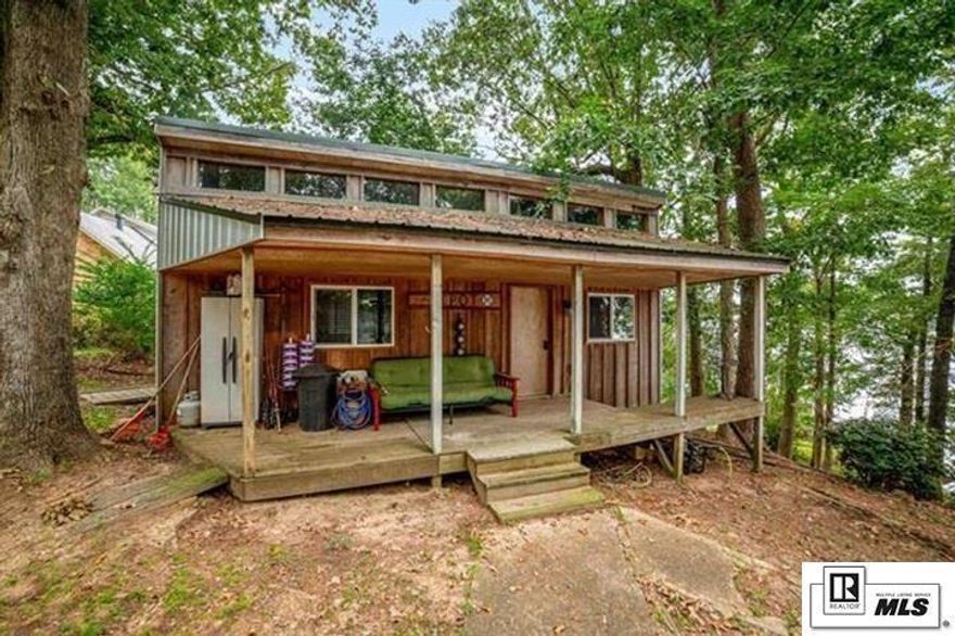 Price drop! Located on one of the best places on the main part of the lake with excellent fishing, a roller cart that has a little buggy that with a click of a button slides your stuff down the hill for you to the boat house…! You've gotta come check this place out! This place is a little getaway haven. Step up onto the front porch on one of the cutest one bedroom cottage, it has a large bedroom that could easily sleep multiple people with hideaway bunkbeds up on the top, with a nice open kitchen and bathroom. Step out onto the front porch and take a look with a beautiful view of the lake! One of the neat things here is the little roller coaster cart. Don’t wanna have to pack your ice chest and all your stuff down to the boathouse no problem here, you can just set it on this little cart, push a button and it will send it down the tracks to meet you at the bottom!  The main house is a nice 3 bed 2 bath mobile home with a huge living room thats been added on to,  that has huge windows overlooking the balcony and water. Step out back of the main house onto the balcony porch and let the world go.. by with spectacular views of Lake Claiborne! Step down to the boat house and here you have a large boat slip for a pontoon boat or a regular fishing boat. This is on the open water of the lake and one of the best spots on the lake! Too much to name here or you just gotta set your appointment and come check this place out!