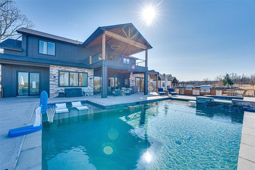 Experience lakeside luxury living in the highly sought-after, gated community of Woodland Shores Estates on Cedar Creek Lake w no STR's. Custom built w high efficiency, fully foam encapsulated & situated on a .65-acre west-facing waterfront lot, exceptional 4-bedroom, 3-bath w breathtaking sunset views & refined modern design. Designer finishes include an integrated sound system (inside & out), decorative lighting, custom cabinetry, wood-look ceramic tile flooring, custom tilework, & abundant storage. Spacious open-concept is ideal for both everyday living & entertaining. Chef’s kitchen features a large island w seating, pendant lighting, granite countertops, custom cabinetry, SS appliances, built-in refrigerator, & THOR gas range w dbl ovens. Butler’s pantry w tons of storage, refrigerator, microwave, beverage center, & sink. Family room showcases a beamed ceiling, floor-to-ceiling gas fireplace w contemporary gas rocks, & 8ft sliding glass doors that seamlessly connect indoor & outdoor. Primary suite is down & features a sitting area, w lake + pool views & private access to outdoor living. Spa-like ensuite bath w custom cabinetry, H+H vanities, soaking tub, sep shower, & WIC. Mother-in-law suite situated down w private outdoor access. Upstairs, offers two generously sized  bedrooms, full bath, & expansive gameroom that opens to a covered balcony—perfect for enjoying panoramic lake views & unforgettable sunsets. Backyard oasis, designed for endless entertaining w heated & cooled pool & spa w tanning ledge, outdoor grill center w a Coyote grill, pellet smoker, & refrigerator, & an expansive covered patio w concrete overlay, automatic privacy screens, & heaters. Additional highlights include a private boat dock for w large boat lift + 2 PWC Lifts, GEM Remotes, finished ceilings, hanging daybed, sitting area, sandy beach playground built at waters edge for kids, invisible fencing to keep pets safely on the property, oversized garage, tons of storage, & extra parking.