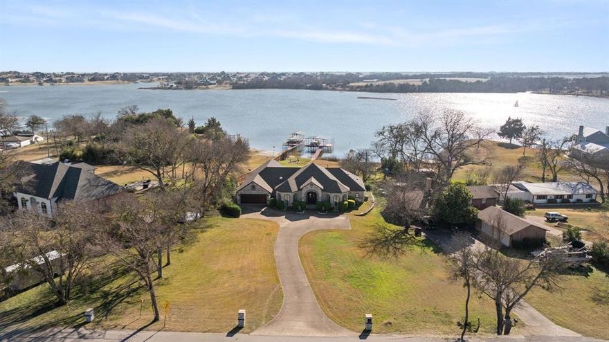 SHHHHHH....WELCOME TO WAXAHACHIE'S BEST KEPT SECRET...LAKE WAXAHACHIE!!! THIS IS THE PLACE TO MAKE FAMILY MEMORIES THAT LAST FOREVER!!! This RARE LAKEFRONT DEEP WATER PROPERTY offers PRIVATE LAKE ACCESS ON OVER AN ACRE, just minutes from historic downtown Waxahachie. The beautiful stone front, two story ENTERTAINER'S HOME features 4 bedrooms and 2 baths (option for 3rd full bath upstairs) with SOARING CEILINGS, ELEGANT WINDOWS, AND SKYLIGHTS THAT FRAME STUNNING LAKE VIEWS THROUGHOUT. EVERY BEDROOM HAS A UNBELIEVABLE LAKE VIEW. The luxurious primary suite is a true retreat with lake views, fireplace, his-and-her walk-in closets, and a spa-like ensuite boasting a jetted tub, walk in shower, dual vanities, skylight and hidden TV mirror. Enjoy a SOUNDPROOF BUILT-IN THEATER, a CHEF'S GOURMET KITCHEN with custom cabinetry, granite countertops, center island, GAS COOKTOP, and built-in oven and microwave overlooking the lake. Double doors lead out to the GORGEOUS view of the lake and tons of PATIO with an WATERFALL INGROUND  POOL to soak up every angle of the Lake. Enjoy year round fun in the pool WITH A TANNING LEDGE & a BAR TOP perfect for bar stools on the pool lake side. Take a stroll down the stone path that leads to the lake and stop by a cozy FIRE PIT for relaxing with family and friends any time of the year. A PRIVATE COVERED DOCK WITH A BOAT LIFT AND JET SKI STORAGE, perfect for fishing or sunset views. WELCOME HOME LAKE LOVERS, where everyday feels like a vacation! HOMES LIKE THESE DON'T COME AVAILABLE OFTEN SO COME SEE TODAY & SUBMIT YOUR OFFER! ;)