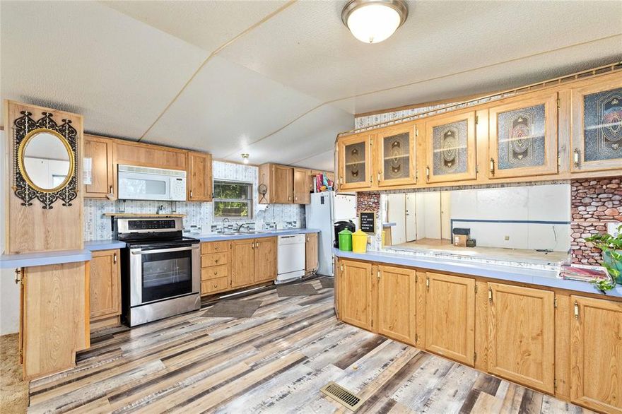 Reduced and priced for quick sale!  Owner is in the middle of removing items and cleaning up, so pardon the mess.  This great 2 bedroom and 2 bath manufactured home is located on an excellent corner lot and features 2 very nice metal buildings with electricity in the back!  Each building is 16 x 24 and could be used for storage, a workshop, a mancave, sheshed or even  office space.  Inside the house there are 2 bedrooms and 2 full baths with a split arrangement.  The open living, dining, and kitchen area provides wonderful space with built-ins including a breakfast bar.  Outside, there is a fenced yard, 2 car carport, and room for a garden or designated pet area if desired.  At this price, it won't last, so schedule a private tour today.