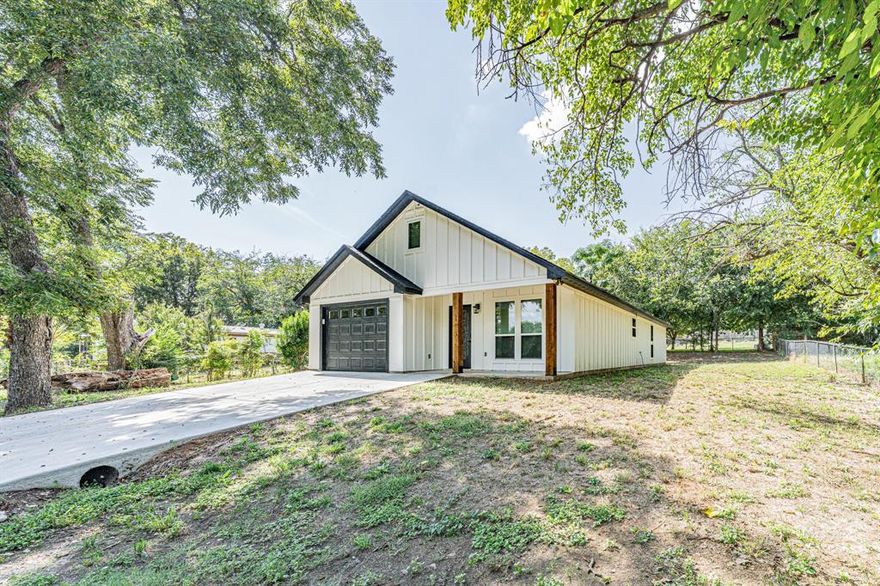 Welcome to your brand-new modern farmhouse retreat just blocks from Lake Granbury and minutes from the charm of Historic Downtown. Designed with today’s lifestyle in mind, this home blends clean architectural lines with thoughtful details throughout.

Inside, soaring vaulted ceilings and an open-concept layout fill the living spaces with natural light. The gourmet kitchen showcases high-quality wood cabinetry, tons of counter space, plenty of cabinets for storage, and a large island perfect for entertaining. A walk-in pantry provides even more space and organization. The kitchen comes complete with stainless steel appliances, including the refrigerator, making it both beautiful and functional. The living room impresses with its dramatic ceiling height, decorative lighting, and a sleek iron ladder that leads up to a bonus loft space enhanced by a live-edge wood bench that adds warmth, function, and a unique touch of character.

The primary suite is a true escape with its spa-inspired bath, featuring custom tilework, granite vanity, and abundant storage. The entire home is finished with arrow-design wood-look tile flooring, complemented by ceiling fans and decorative lighting throughout.

Outside, you’ll find a wide driveway, a covered front porch, and a rear patio that expands your outdoor living options. The generous backyard is ready for relaxation or play. Built with foam insulation for comfort and efficiency, along with a new septic system that irrigates the yard, this home offers peace of mind and long-term savings.

Whether you’re envisioning it as your first home, a lake getaway, or an investment property with Airbnb potential, this home’s location and design make it a standout choice just blocks from the water and minutes from downtown. Come experience for yourself all the extras that make this home stand out.
