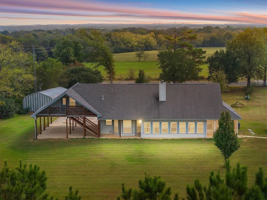 Bring the animals, bring the equipment, and bring the dreams. This 11 acre Grand Saline property is set up for country living with the perfect mix of open pasture and beautiful mature trees, especially surrounding the peaceful pond. Fully fenced with a brand-new pipe entrance and gated drive, you will feel the privacy and quiet the moment you arrive. The main home offers three bedrooms, two baths, a cozy living room with a brick fireplace, and a great kitchen with plenty of cabinet storage. A bright sunroom spans the back of the home, giving panoramic views of the land and a perfect spot to enjoy morning coffee or quiet evenings. Attached under the same roofline, with its own private entrance, is a brand-new one-bedroom, one-bath apartment that is ideal for guests, extended family, or rental income. Outside, the property includes a one-bay shop, a second large two-bay shop with a covered lean-to, a storm shelter, and plenty of space for equipment, animals, RV storage, or home-based projects. Land like this is hard to find, already improved, fenced, and ready to enjoy, just minutes from town with a true East Texas country feel.