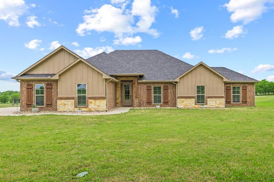 Enjoy peaceful country living on 1.58 acres in Lone Oak, TX with this spacious and inviting 5-bedroom home (one bedroom currently used as an office). Offering a perfect blend of comfort and functionality, this property provides room to spread out while still enjoying modern conveniences.
Inside, you’ll find an open floorplan enhanced by hand-scraped hardwood floors throughout the main living areas and carpet in the bedrooms for added comfort. The cozy living room features a beautiful painted brick and stone fireplace with a raised hearth, creating a warm focal point that can be enjoyed throughout the main space—perfect for chilly evenings. The kitchen is designed for both everyday living and entertaining, showcasing quartz countertops, a center island with seating, stainless steel appliances, and a convenient pantry for extra storage. The primary suite offers a relaxing retreat with a spacious layout and a large walk-in closet. The primary bath includes dual sinks, a garden tub, and a separate shower, providing both comfort and functionality. A utility room with built-in cabinets adds even more convenience. Step outside to a covered back patio overlooking a huge backyard, perfect for outdoor gatherings or simply enjoying the serene setting. The property also features a picturesque pond, adding to the charm and natural beauty of the land.  Garage features epoxy flooring.  With generous space, thoughtful features, and a tranquil setting, this Lone Oak property offers the ideal balance of country living and modern comfort. Plus, it is zoned to highly sought after Lone Oak ISD! Lone Oak High School has recently completed a redesign that added enhanced athletic facilities, science and health labs, a band hall, concession and dining areas, and an ag barn with instructional space.  Don’t miss your chance to make it yours!