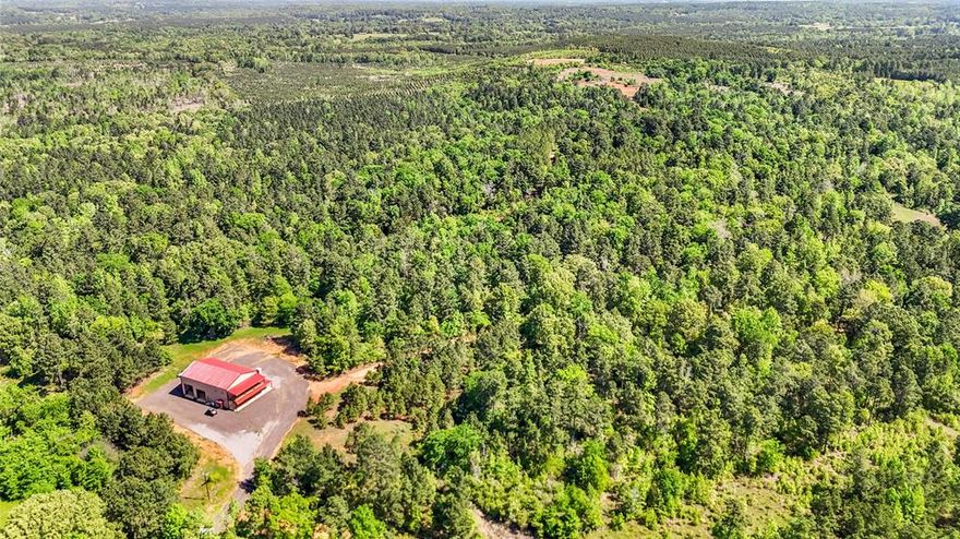 Private 398-Acre East Texas Retreat with Stocked Lake, Barndo, and Prime Wildlife Features! Welcome to your dream escape in the heart of East Texas—398 secluded, heavily treed acres just outside Jacksonville, featuring a stunning 17-acre stocked lake fed by a year-round creek and two natural aquifers. Loaded with perch and bass and complete with two docks, a boat slip, and fish feeders, this is a fisherman’s paradise. Tucked away on the property sits a charming 1,848 sq ft barndominium offering 3 bedrooms and 3.5 bathrooms across two stories. It's attached to a spacious 40x70 shop with an elevator lift to the second floor—perfect for both work and play. Enjoy cozy evenings on the side porch beside a beautiful brick, wood-burning fireplace. Access is easy via a reclaimed crushed asphalt driveway leading through a gated entrance—no easements, total privacy. The entire property is fenced with 5-strand barbed wire and features miles of cut-in roads and trails for ATVs, hiking, or exploring. An outdoor enthusiast's dream, this property includes 4 premium Redneck deer stands, 4 electric feeders, and 3 protein feeders, making it ideal for hunting or wildlife watching. Whether you're looking for a private family getaway, a hunting ranch, or a long-term investment with recreation potential, this one-of-a-kind East Texas property delivers.