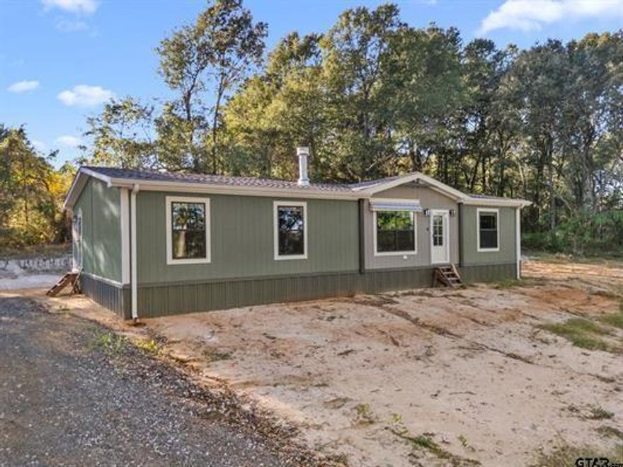 Welcome to this beautiful 1.72 acre, heavily wooded homesite just off Rhones Quarter Road. This lovely manufactured home, designed and built by Clayton Homes, offers a thoughtful layout and quality finished throughout. The split bedroom design and open concept living and kitchen area make it perfect for today's buyers seeking an affordable yet stylish home. The kitchen features custom shaker style cabinetry, a large stainless farmhouse sink, and a spacious island with a durable hard surface countertop, Stainless appliances, including an electric range, oven, microwave, dishwasher, and refrigerator- complete the space. The living and dining areas flow together seamlessly, creating an inviting space ideal for entertaining. Throughout the home, custom vinyl flooring offers durability and easy maintenance. The living area fireplace with mantle adds warmth and charm. The primary suite is generously sized and includes a luxurious bath with double sinks, a walk in marble shower, a large garden tub, and a walk-in closet. The guest bath also offers double sinks and a tub and shower combination. The level homesite provides ample room to add a shop or garage and features a beautiful mix of pine and hardwood trees. Set back from the main road, this property offers both privacy and a natural forest buffer. Built in 2025 and placed on-site within the last three months, this home is move-in ready and waiting for it's new owners. Come take a tour!