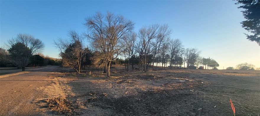 This beautiful and private 1.912-treed-acre lot offers the perfect blend of country living and city convenience. Located just outside city limits, approximately 30 miles from Downtown Dallas and Fort Worth! You'll enjoy the benefit of lower property taxes and the freedom of minimal restrictions when building your dream home! Adding a workshop, a guest home, or a horse is worth considering! The property has been cleared for your building site! The quiet, peaceful serenity this location offers is an escape from the hustle and bustle of the city! This is a rare opportunity to have the best of both worlds-rural tranquility and urban convenience.
