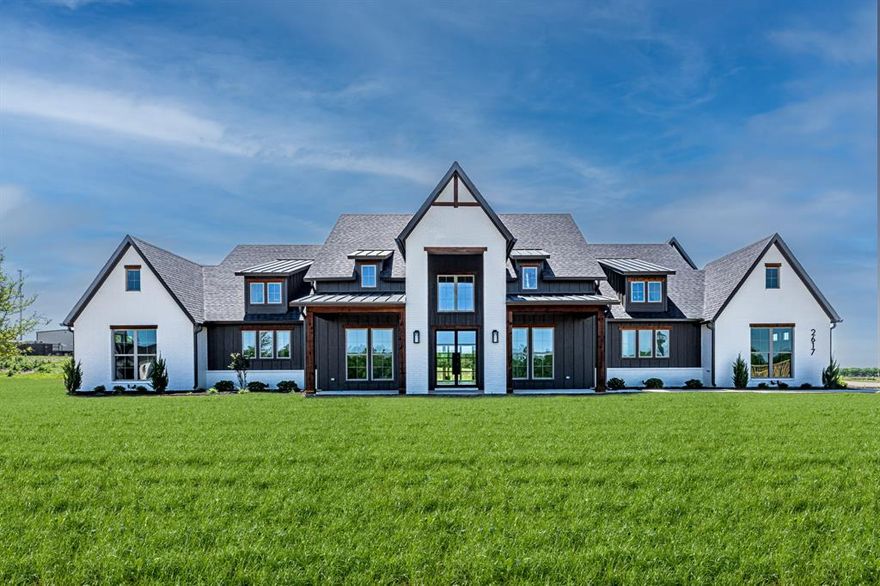 Step into upscale Texas living in this stunning 4-bedroom, 4.5-bath custom masterpiece on nearly an acre in the exemplary Argyle ISD. Thoughtfully designed for both everyday comfort and unforgettable entertaining, the open-concept effortlessly connects the kitchen, dining, and living spaces in a light-filled, welcoming layout. The kitchen features an oversized island with built in 60” refrigerator, pro-style range and microwave drawer. Walls of glass—anchored by 16’ Bi-fold doors that open to the expansive covered rear patio create a seamless indoor-outdoor lifestyle perfect for entertaining. Enjoy evenings by the wood burning outdoor fireplace, with a gas and water stubbed out ready for your future outdoor kitchen, all overlooking an open backyard retreat. The great room commands attention with a contemporary sleek linear electric fireplace with built-ins and floating shelves. Every detail reflects refined craftsmanship with the custom wine room, floating shelves, engineered white oak wood floors, quartzite countertops, and carefully curated designer lighting with champagne bronze plumbing fixtures. The chef’s kitchen is as functional as it is beautiful, featuring a spacious walk-in pantry with custom cabinetry, while the dining area is enhanced by a stylish built-in wine bar—perfect for entertaining. The primary suite is a true sanctuary, offering a spa inspired walk in shower with dual shower heads, a stand alone bath tub and a large custom walk-in closet with island designed for luxury living. The home also includes a secondary en-suite, private office, and two additional bedrooms with ensuite bath ideal for guests or multigenerational living. This is more than a home—it’s a lifestyle defined by elegance, space, and exceptional design. The home has been completed and is Move in Ready.