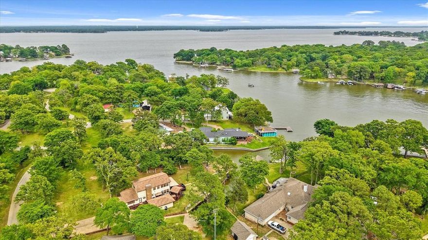 Lakefront Retreat with Stunning Views and VRBO Potential 
ailable. Welcome to “The Duck Inn,” a spacious and well-maintained 3-bedroom, 3-bath lake home that sleeps up to 15. Situated on a large, tree-shaded lot with panoramic water views, this property offers peace, privacy, and income potential.
Interior features include two living areas, two master suites, and a bonus bunk room that can serve as a fourth bedroom or office. The open-concept layout showcases rustic finishes with wood flooring, exposed beams, and roughed cedar ceilings. The kitchen is equipped with solid surface countertops, tile backsplash, double ovens, and a breakfast bar.
Enjoy outdoor living with a wraparound porch, built-in grilling station, and dedicated dining area. The boathouse includes a remote-controlled power lift for both boat and jet ski, plus a lake pump and full-yard sprinkler system. Ample parking is available on the large concrete drive.
Furnishings are included if you like — just bring your swimsuit and fishing pole and start living the lake life yours or make it a turnkey VRBO.