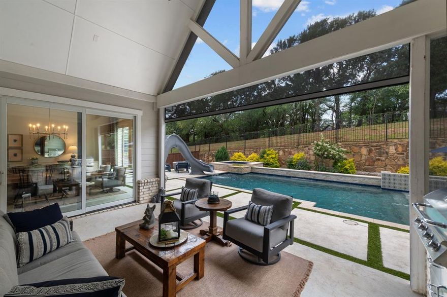 Welcome home to this well-appointed estate in sought-after 5T Ranch, where no detail has been overlooked. Upon stepping in, one quickly realizes there are custom touches throughout the home, from the upgraded kitchen to the resort-style backyard oasis.  Moving through the main floor is effortless because of the functional floor plan that flows from the grand two-story foyer to the main living, kitchen, and dining room. Once in the kitchen, the homeowner will enjoy Cafe appliances, an oversized counter-height island, large walk-in pantry, and decorative luxury lighting. From the kitchen, one can enjoy views of the dining room and main living area, with vaulted ceilings, a focal-point fireplace, and a wall of windows overlooking the outdoor living spaces. The primary suite is an escape with board-and-batten wall, views of the backyard, spa-like bath with rainfall shower, soaking tub, and custom closet. Other main floor highlights are a sophisticated study with built-in cabinets and a private guest suite with a walk-in closet. Continuing upstairs, a split staircase will take you to your secluded game room away from the hustle of the rest of the home, and on the other side, you will find two bedrooms with a Jack and Jill bath and walk-in closets. Outside, the designer touches continue with a covered patio featuring an outdoor kitchen with a built-in grill and fridge, which will please any grill master, as well as automatic screens and a large fan to cool off during those warm Texas summers. The backyard pool is the center of the fun, with a hot tub, tanning ledge, waterslide, and water feature all overlooking the community walking trail with large trees. This property has so many designer upgrades, it is a must see!