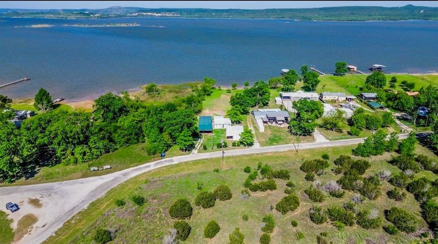 This Possum Kingdom Lake property offers a unique combination of a private beach and direct access to an expansive Brazos River Authority greenbelt, creating a wide-open feel with massive lake views that extends far beyond the lot itself—without the added property tax burden. Owned by the same family for decades, this is a choice lakefront location. The existing cabin provides a simple, usable footprint for immediate enjoyment, while the garage and guest suite offer well-maintained space for guests, storage, or weekend flexibility. For families new to PK this is where lake life really works… room to run, play, and gather, with easy access to the water and space to grow. Over time, the setting easily supports a future custom build that takes full advantage of the beach, views, and surrounding open space. Short-term rental potential adds another layer of versatility, making it possible to enjoy the property while generating income. Recent resurvey increased area of lakefront based on 1000 elevation.