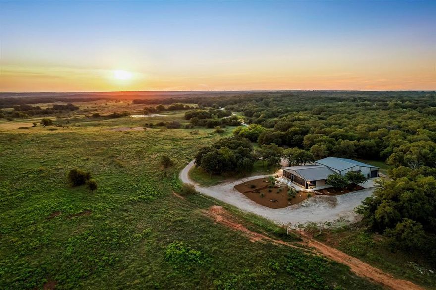 JUST IN TIME FOR HUNTING SEASON! Experience the best of Montague County with this 138± AC turn-key ranch retreat complete with a beautiful, high-end barndominium. Foxhole Ranch is located less than 1.5 hours from DFW and just minutes from the charming, historic town of Saint Jo. This property offers the ideal blend of hunting, recreation, and comfort, anchored by Turkey Creek with 5 additional ponds that provide reliable surface water for wildlife and livestock. The land features a mix of hardwood timber, open pasture, rolling terrain, and an extensive trail system. Whitetail deer, turkey, and other native game thrive in the mix of oaks, pecans & elms. The property includes several blinds and feeders already in position, giving sportsmen a true ready-to-hunt setup. At the center of the ranch is a custom 2-bedroom, 3-bathroom barndominium that comfortably sleeps 11+ guests. Designed for functionality and entertaining, it features an expansive game room with vaulted, wood ceiling and bar, a dedicated ammunition room, and a full laundry room. The living spaces extend to the outdoors including a screened-in porch with built-in propane grill and granite bar and a built-in firepit with panoramic sunrise and sunset views. The drive-through garage for vehicles and equipment is conveniently attached to the barndominium for easy access. The residence was fully designed and furnished by a professional designer can be sold fully furnished, allowing for immediate use as a weekend retreat, hunting lodge, or family getaway. The ranch is accessed through a gated entry, offering both security and privacy. Nearby Saint Jo provides charm and convenience with its historic square, wineries, and live music venues. Even better? The ranch is surrounded by several large acreage neighbors providing privacy. Currently ag exempt. NO PIPELINES. NO MAJOR TRANSMISSION LINES. NO WIND FARM VISIBLE FROM PROPERTY!