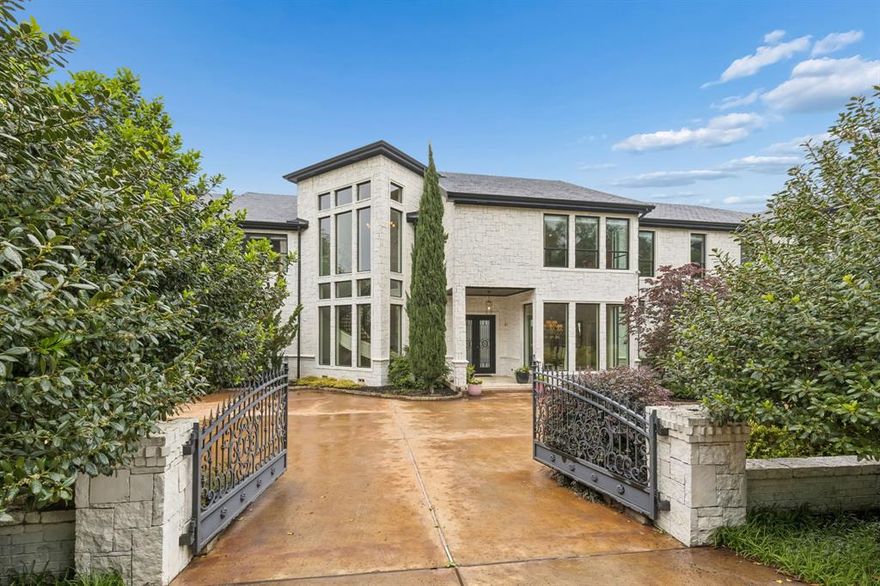 Set on a beautifully landscaped acre in coveted Bluffview, this elegant estate pairs timeless architecture with refined modern comfort, creating an exceptional indoor-outdoor lifestyle. A dramatic marble entry with soaring 25-foot ceilings and a sweeping staircase sets the tone, opening to expansive, light-filled living spaces designed for both everyday living and entertaining. At the heart of the home, the chef’s kitchen is anchored by an impressive 15-by-7-foot marble island with seating for ten. Outfitted with Wolf appliances, dual dishwashers, a butler’s pantry, and a custom walk-in wine room, it flows effortlessly into the surrounding living and dining areas, all of which open to the main patio. The private primary wing offers a peaceful retreat, complete with two fireplaces, a sitting area, morning bar, and direct access to a secluded patio with a newly built gas fire feature. A spiral staircase leads to a dedicated second level with four oversized walk-in closets, while the suite also includes private laundry and a flexible bonus space nearby. Each additional bedroom is generously sized and accompanied with its own en-suite bath and walk-in closet. Upstairs, a spacious family and game room with a full kitchen is complemented by a theater room, craft space, additional laundry, and elevator access. A gorgeous, oversized office provides the ultimate work-from-home environment, featuring a built-in library, dual work areas, a central lounge with fireplace, and a private patio. Outdoors, the grounds rival a private resort, showcasing a stunning pool and spa, professional landscaping, a striking crescent-shaped gas fire feature, and a fully equipped outdoor kitchen. A 969-square-foot guest house with a bath adds flexibility for visitors or extended stays. With eight fireplaces throughout, the home is layered with warmth and ambiance. A true Bluffview lifestyle estate, thoughtfully designed for elevated living, comfort, and unforgettable entertaining.