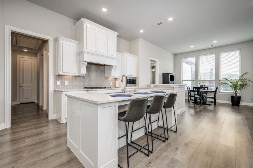 Step into refined ONE-STORY living in this beautifully upgraded single story home designed for both everyday comfort and exceptional entertaining. Featuring plantation shutters throughout and wide-plank wood flooring across the main living areas, this expansive open-concept layout seamlessly connects the kitchen, dining, and living spaces. The high-impact designer kitchen is a true showpiece, boasting white flat-panel cabinetry, Level 2 Silestone countertops, a striking apron-front Kohler sink set in the oversized island, stainless steel appliances, double ovens, and a 5-burner gas cooktop. An upgraded backsplash adds the perfect finishing touch, making this space as functional as it is stylish. The extended primary suite offers a private retreat with plush upgraded carpet and a luxurious bath featuring white cabinetry and premium finishes. A dedicated study provides an ideal work-from-home space, while thoughtful upgrades continue throughout the home with enhanced tile selections and upgraded carpeting in secondary bedrooms. Step outside to your own backyard oasis. Mature, tall trees create a serene backdrop for the saltwater pool, putting green, and fully equipped outdoor living area complete with a fireplace, outdoor kitchen, and pergola — perfect for hosting year-round gatherings. Additional highlights include: 2024 roof Tankless water heater, a 3-Car Garage with epoxy flooring and overhead storage, Bonus outdoor planters in the front yard to remain, and  2018 washer & dryer and 2020 refrigerator included. Lantana residents enjoy access to top-
rated schools, scenic walking trails, resort-style pools, new pickleball courts, amenity centers, and more. 805 Haverford Lane is a meticulously maintained home that combines luxury finishes, practical upgrades, and resort-style outdoor amenities. Don’t miss this rare opportunity to enjoy elevated living both inside and out.