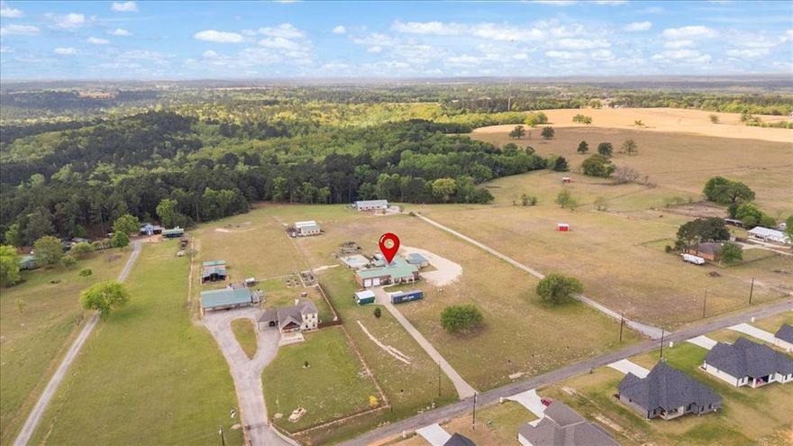 15515 CR 434 - Situated on just over 4 acres in Lindale, this spacious property is full of possibilities and designed for both everyday living and functionality. Offering over 3,000 square feet, the home provides generous space inside and out, complete with a swimming pool, 19.3x24.3 and 29x15 studios with AC and water, 27.5x25 shop, and 36.6x24.3 RV covering. Inside, the kitchen is a true centerpiece with abundant cabinetry wrapping around multiple walls, a prep island with sink, and an ideal layout for cooking and entertaining. A standard pantry handles everyday essentials, while a second oversized pantry offers incredible storage for bulk items, appliances, and food prep needs. The layout offers flexibility for a variety of lifestyles. One guest bedroom features a large walk-in closet plus an additional room-sized closet that could easily serve as a home office, makeup studio, or workout space. A second guest bedroom or bonus room with its own bathroom is spacious and versatile. The primary suite is a private retreat with a spa-like bathroom and direct access to the patio, perfect for enjoying peaceful views of the pool and surrounding nature. Another bonus is a dedicated office close to the master bedroom. Energy efficiency is a major bonus with fully paid-off solar panels and a backup storage battery already in place. If you are looking for space, functionality, and room to make it your own, this Lindale property checks all the boxes.