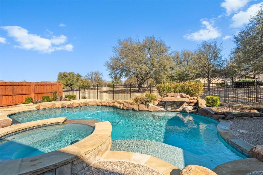 Stunning Highland home with sparkling pool and spa in sought after Lacima subdivision of Stonebridge Ranch. Imagine coffee on your front porch every morning and cooking with friends on the back porch in the early evening. Premium greenbelt lot with panoramic views, built in outdoor cooking area, pool and spa, and waterfall on almost a quarter of an acre.  This lovely home has 5 full bedrooms with primary and full guest suite located downstairs.  Popular floorplan with spacious chefs kitchen with double ovens, large island, a butlers pantry, large walk in pantry and gas cooktop. Hardwood floors through the entertaining spaces downstairs. 4 living areas including a formal living room, family room, gameroom and media room.  Downstairs living space has a beautiful stone fireplace and custom built in with view of the pool and spa.  Primary bedroom has a sitting area overlooking the greenbelt. AMAZING primary bathroom has been completely remodeled. Your private RETREAT awaits ! Stonebridge amenities include beach lagoon pool, splash pad,  tennis and pickleball, basketball courts, parks, walking trails and ponds. 2 AC units replaced 2021 and water heater converted to tankless in 2020. Several rooms recently painted and all upstairs carpet replaced.