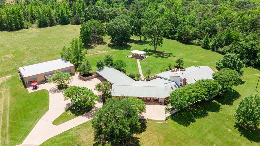 Custom built estate on 10 open acres offering rare flexibility for multigenerational living private retreat use or future income potential. Built in 1979 by the sellers father the approximately 6000 sq ft main home features 6 bedrooms and 6 bathrooms including an attached mother in law suite with private entrance living area kitchenette walk in closet with built ins and handicap accessible bath.

Interior highlights include two living areas sunroom formal dining vaulted beaded wood ceilings luxury hardwood floors and a wood burning fireplace. The gourmet kitchen offers an oversized island custom glass front cabinetry walk in pantry double ovens and ice maker designed for everyday living and entertaining.

A fully separate cottage provides approximately 1500 sq ft of heated and cooled living space plus 1000 sq ft of storage with two bay doors kitchen dining area multiple bedrooms and two bathrooms ideal for guests or extended family.

Outdoor amenities include a gunite chlorine pool with heated hot tub covered and uncovered patios and expansive open views. Property is approximately 90 percent open with wooded backdrop metal roof community water and septic system. Located minutes from a charming small town with vintage shops and character.