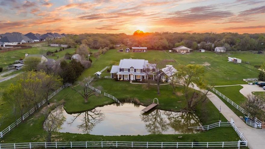 Experience refined country living on this nearly 3 acre private estate in the heart of Argyle, located within highly sought after Argyle ISD and just minutes from Liberty Christian School. This stunning 4 bedroom, 3.5 bath modern farmhouse blends timeless design with upscale comfort, offering a picturesque homestead ideal for both relaxation and recreation. Framed by sweeping pasture views and a stocked pond, the property invites you to embrace an elevated outdoor lifestyle, cast a line at sunset, gather under the expansive covered patio, or unwind beside the resort style 10 foot saltwater pool. Thoughtfully designed grounds include garden space, mature fruit trees, and a charming 3 stall barn, perfect for equestrian or hobby farm enthusiasts. Inside, curated finishes and warm textures create an inviting yet sophisticated ambiance with white oak hardwoods, custom barn doors, and designer shiplap details complemented by expansive windows that flood the home with natural light and showcase serene countryside views. The gourmet kitchen serves as the heart of the home, featuring a grand island, stainless steel appliances, a farmhouse sink, and an adjoining breakfast nook with a custom built in banquette ideal for everyday living and entertaining alike, while a well appointed laundry and mudroom adds convenience and functionality. The first floor primary suite offers a true retreat with a spa inspired bath featuring dual vanities, a walk in shower, and a classic clawfoot soaking tub. A private downstairs study with barn doors provides flexibility as a fourth bedroom, and upstairs spacious game and media rooms create the perfect setting for leisure and gatherings. Enjoy the benefits of an ag exempt property with no city taxes, all while being just minutes from modern conveniences, this is more than a home, it is a lifestyle of quiet luxury, open space, and timeless Texas beauty.
