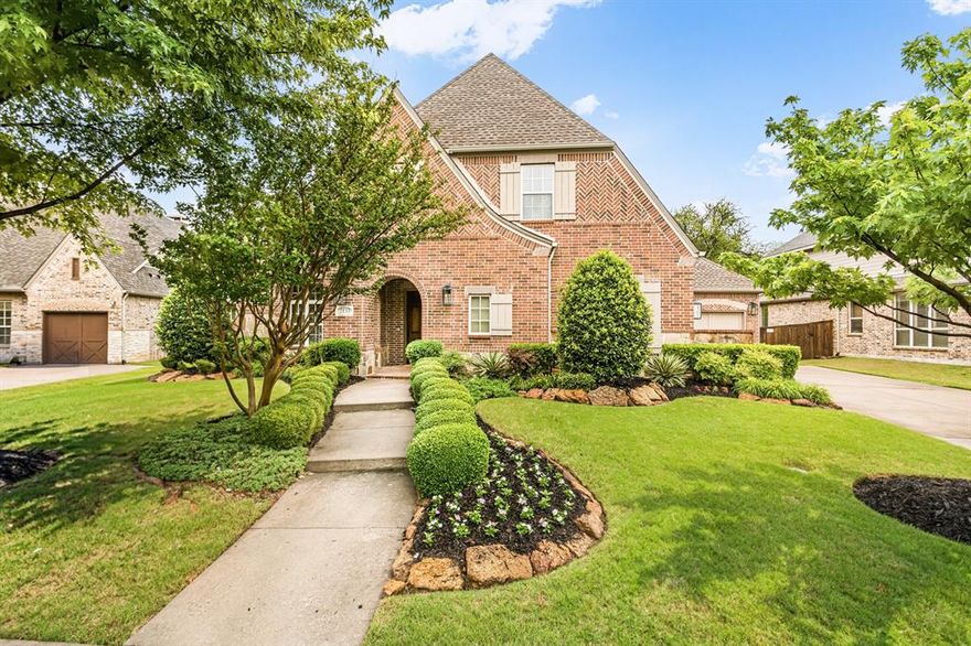 Elegant two-story 5-bedroom, 5.5-bathroom home with 5,018 square feet in Star Creek in Allen, Texas on a wooded creek-greenbelt lot. This Highland home features hardwood floors, updated LED lights-chandeliers, a curved staircase, and detailed moldings create a refined entrance. The formal dining room features an updated chandelier and connects to a secondary office-flex space with built-in knotty alder cabinetry & shelving. The private study includes a beamed ceiling, custom shelving, and an adjacent powder bath. A spacious living room anchors the open floor plan with wood ceiling beams, a floor-to-ceiling tiled fireplace, and windows overlooking the wooded backyard. The updated kitchen features expansive granite counters, a large island with separate bar seating, abundant knotty alder cabinetry with glass fronts, tile backsplash to the ceiling, and high-end appliances, flowing into a sunlit breakfast nook. Both the primary suite and guest suite are on the main floor. The guest suite offers an ensuite full bath with a walk-in shower. The primary suite features bay windows, granite dual vanities, a separate soaking tub and shower, and a large walk-in closet. The second level includes an extended game room with a built-in bar and a private balcony overlooking the wooded lot, a tiered media room with a passthrough window, and three secondary bedrooms, each with a full bath. Outdoor living features a covered patio with a fireplace overlooking a wooded greenbelt-creek lot, professional front and back landscaping, a putting green, and a 3-car front-entry garage. Star Creek amenities include 2 community pools, a playground, sports court, clubhouse, and walking-jogging trails. Zoned to Jenny Preston Elementary. Minutes from Watters Creek, the Villages of Allen-Fairview, Allen Premium Outlets, Target, Costco, Dick's, Bonefish Grill, and Cinemark. Refined luxury living in Star Creek, Allen, Texas.