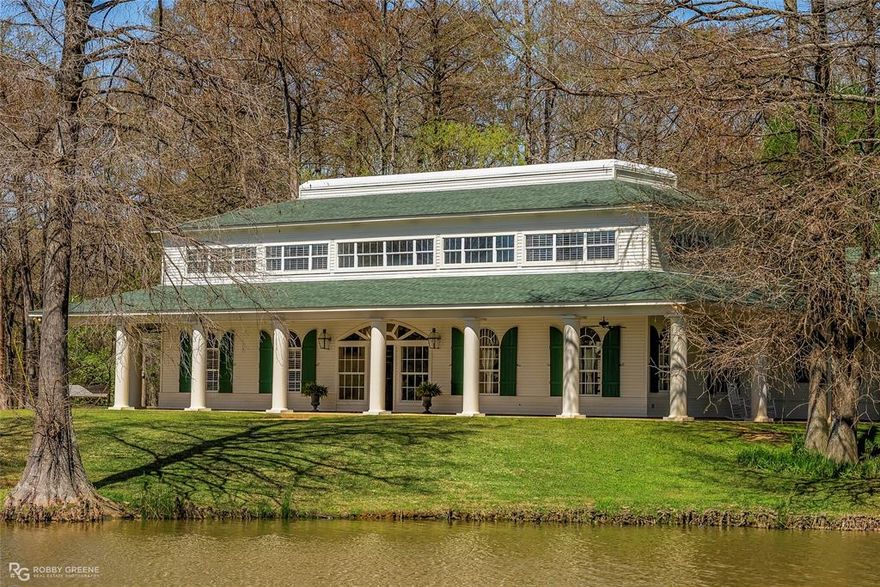 Step into your dream sanctuary, privately situated on 2.65 acres with stunning lake views. This pristine residence welcomes you with a grand entryway that flows seamlessly into a breathtaking living area, showcasing soaring ceilings, rich wood flooring, and expansive windows that invite a cascade of natural light throughout the space. The heart of this home is a chef's paradise—the kitchen boasts a generous island, abundant counter space, and a well-appointed butler's pantry, perfect for culinary adventures. A cozy breakfast nook invites you to enjoy your morning coffee while enjoying peaceful views. Retreat to the lower level, where the private primary suite awaits. It features a luxurious soaker tub for relaxation and a spacious walk-in closet that doubles as a safe room. An elegant office space with built-in bookshelves and secure wall storage offers the ideal setting for productivity and inspiration. Conveniently located outside the office, a closet, prepped to house an elevator, ensures effortless access to the upper floor. On the second level, discover four generously sized bedrooms—two with exquisite en-suite baths and expansive walk-in closets. A third bedroom boasts a jack-and-jill bathroom that elegantly connects to the hallway, ensuring privacy and accessibility. The property's exterior features an automatic privacy gate and a three-car garage, which includes a convenient half bath. The impressive 478 sqft storage area is designed as a workshop but has the potential to be converted into additional living space, offering endless possibilities. And for pet lovers: a state-of-the-art, 20'x20' heated and cooled concrete-floored kennel with running water. Unwind on your inviting wrap-around porch, where you can bask in the tranquility of nature and watching the wildlife. This extraordinary home and its stunning views are not to be missed! Arrange your private showing to seize the opportunity for this unique property and make it your dream home today.