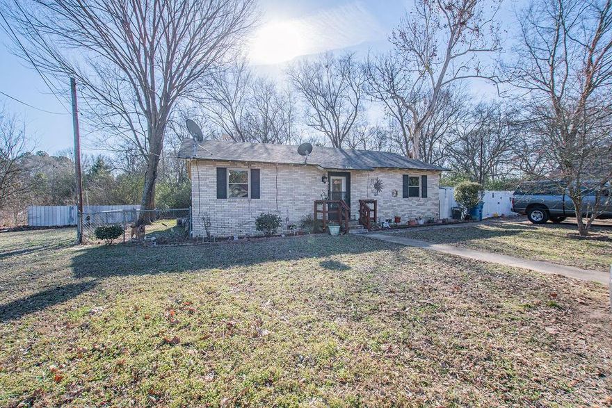 Welcome to this charming single story brick home in the heart of Quitman Townsites, ideally located just minutes from local hospitals, downtown Quitman, shopping, dining, and entertainment. Situated on a spacious 0.26 acre subdivision lot, this well maintained 3 bedroom, 2 bath home offers 1,682 square feet of flexible living space. City of Quitman stated the zoning may allow light commercial opportunities, making this a unique option for homeowners, investors, or small business use (buyer to verify with city).

Step inside to a generous living area featuring ceiling fans and a blend of carpet, laminate, tile, and vinyl flooring throughout. The kitchen includes a pantry, dishwasher, and easy flow into both a formal living or dining combination and a kitchen eating area; perfect for entertaining or daily living. The spacious primary suite offers a relaxing sitting area, walk-in closet, and an ensuite bath with dressing area and flexible shower and tub options. Two additional, large bedrooms provide comfortable space for family, guests, or a home office. A dedicated utility room, interior sitting area & satellite access add convenience and functionality. Outside, enjoy a fully fenced yard with both wood and chain link fencing, offering room for pets, outdoor gatherings, or future improvements. Additional highlights include central electric cooling, central gas heat, public utilities, pier-and-beam construction, brick veneer exterior, and a composition roof. Located within Quitman ISD and close to essential services and community amenities, this property combines small-town charm, everyday comfort, and exciting potential for residential or light commercial use—an opportunity you won’t want to miss.