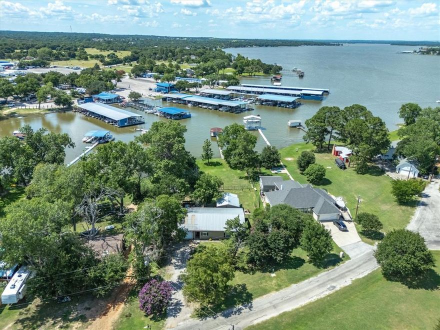 Eagle Mountainn Lake Cottage on a great subtle sloped lot overlooking West Bay Marina and fan fav West Bay Grill & Bar! (Scotty's -- IYKYK!)  FUN lake getaway that includes the cutest detached guest house, plus great patio decking areas and tons of outdoor space to enjoy its pretty waterfront lot!  Open design interior with 2 living areas in main house with 1 car garage, a guest house includes full kitchenette, a spacious outdoor metal storage building, and a boat dock with lift literally located right by the marina gas station!