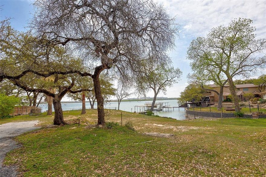 Discover the perfect canvas for your dream home on this nearly one-acre deeded lakefront lot, boasting approximately 160 feet of prime waterfront. Nestled among mature trees and offering both stunning sunrise and sunset views, this rare property combines natural beauty with thoughtful preparation on future building plans.
Enjoy panoramic open water views and an easy connection to nature, all just minutes from the conveniences of downtown. Perfect spot to enjoy fireworks, and holiday boat parade and air show. Architectural and landscape plans are included, providing a head start on building the home you’ve always envisioned. Barrel terra cotta color roof tiles salvaged from the prior home are also included, offering a touch of character and sustainability.
Whether you're planning a peaceful retreat or an entertainer’s paradise, this exceptional lot offers an unmatched opportunity to bring your vision to life on the water.