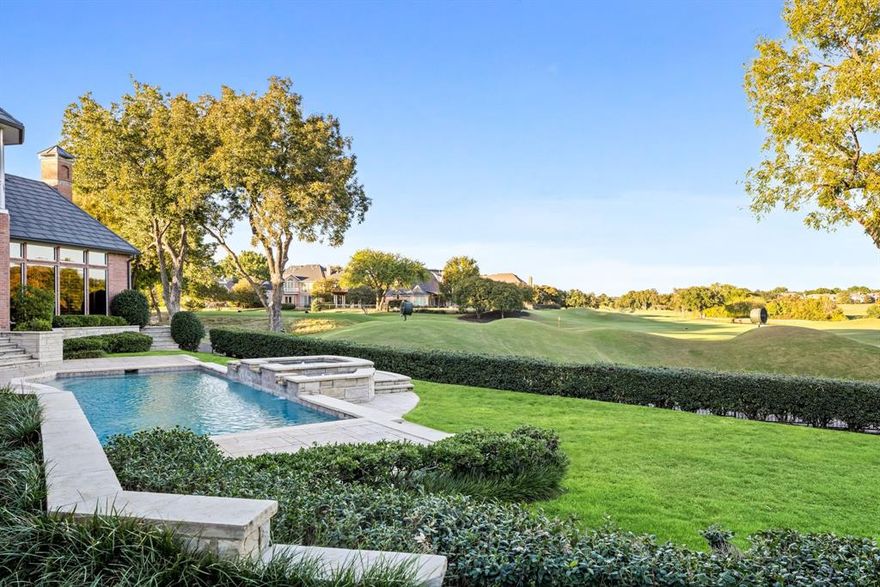 Tucked away on a quiet cul-de-sac surrounded by lush, mature trees, this breathtakingly exquisite estate offers more than 9,000 square feet of refined living overlooking Number 16 of the Gleneagles Queen’s Course. A circle drive, grand double-leaded glass doors, and manicured landscaping set the stage for the sophistication within. Inside, the home impresses with soaring ceilings, marble floors, and intricate crown molding. Sunlight floods through expansive windows framing sweeping views of the pool, creek, and rolling hills beyond. A dramatic curved staircase greets guests in the foyer, while the formal living and dining spaces are complemented by a butler’s pantry with built-ins—perfect for entertaining in style. The den, featuring a stately wood coffered ceiling and wet bar, looks out to tranquil golf course views. A game room with a second wet bar offers the ideal space for relaxed gatherings. The gourmet kitchen is a true centerpiece with Thermador and GE Profile appliances, a massive island, a FiveStar commercial-grade 6-burner cooktop, double ovens and dishwashers, and new custom cabinetry. The first floor primary suite provides a sanctuary of luxury with a sitting area overlooking the greens, a cedar closet, and a spa-like bath with a freestanding tub, marble shower, dual vanities and toilets, and a bidet. An upstairs second primary in-law suite features a balcony and fireplace. Beyond the interiors, enjoy a resort-style outdoor experience with an expansive pool deck, lush play yard, and full pool bath. Thoughtful details abound, from a four-car garage to a potting room workshop off the garage and a back staircase for convenience. An extraordinary blend of craftsmanship, comfort, and setting—this estate captures the essence of luxury golf course living in one of North Texas’s most prestigious communities.