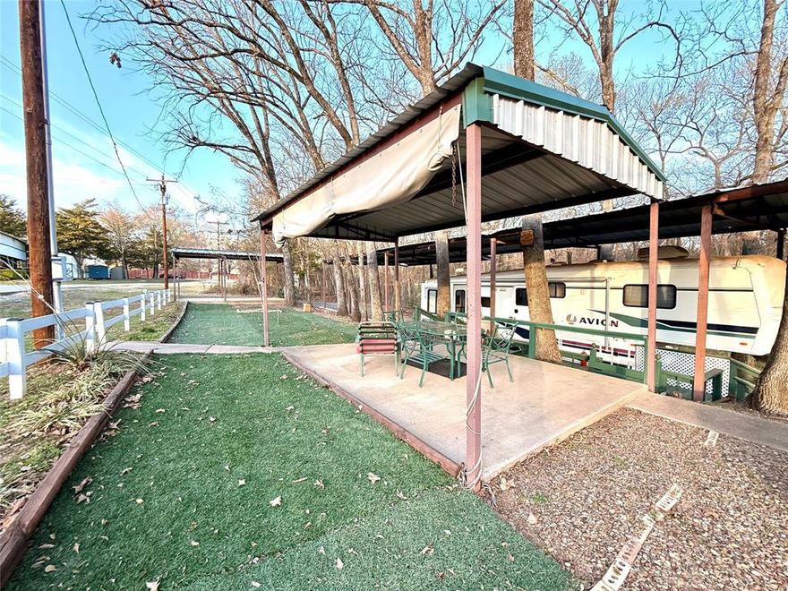 Located in White Oak Shores gated community on Lake Fork this is almost an acre of deeded land and all that's needed for full or part-time living. There is a furnished, 1998 Fleetwood, 35' 5th wheel RV with three pull outs and is overlooking the oversized lots at back. Tons of outdoor living space with a covered lounge area and large fire pit. There are two, two car, metal carports on concrete pads, and an impressive 80'x20' metal cover over the RV. There are also two storage buildings. The larger, wood, storage building is plumbed for washer and dryer and has a small water heater, window ac unit and loft for extra storage. White Oak Shores offers a private boat ramp and fishing pier for residents and guests, along with a clubhouse and swimming pool.
