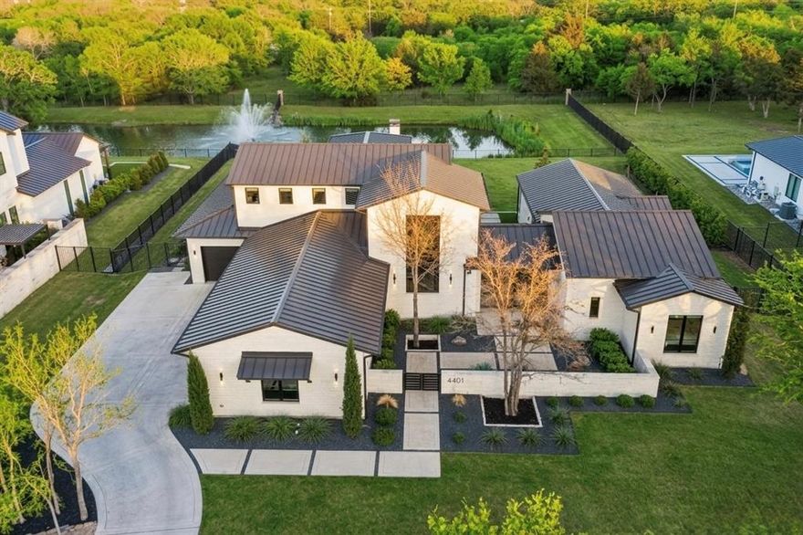 A rare opportunity in gated Saddleback Estates, this Atwood Custom Homes residence sits on a sprawling one-acre lot with a private pond and a striking modern aesthetic. From the moment you arrive, a dramatic glass-door entry and a wall of windows frame views of a custom water feature, setting the tone for the exceptional design found throughout. The home offers 4 bedrooms, 4.1 baths, and a 4-car garage, with predominantly downstairs living designed for both comfort and elevated entertaining. The open-concept living room, kitchen, and breakfast area create a seamless central gathering space, while a secondary catering kitchen tucked behind the main kitchen allows for high-level entertaining with ease. A private office with a sleek glass wall delivers a modern, inspiring workspace. The game room is a destination of its own, featuring a wet bar with wine fridge and direct access to the patio, perfect for hosting and indoor-outdoor living. Step outside to a true resort-style retreat: a covered patio with built-in grill and fireplace overlooks a custom Claffey pool and spa complete with multiple water features, offering year-round enjoyment and unforgettable views. The private primary suite is a serene escape overlooking the backyard, paired with a luxurious spa-inspired bath featuring an oversized walk-in shower, soaking tub, dual vanities, and separate walk-in closets. Thoughtfully designed, impeccably built, and effortlessly stylish, this home blends modern luxury with everyday livability in one of the area’s most exclusive gated communities.