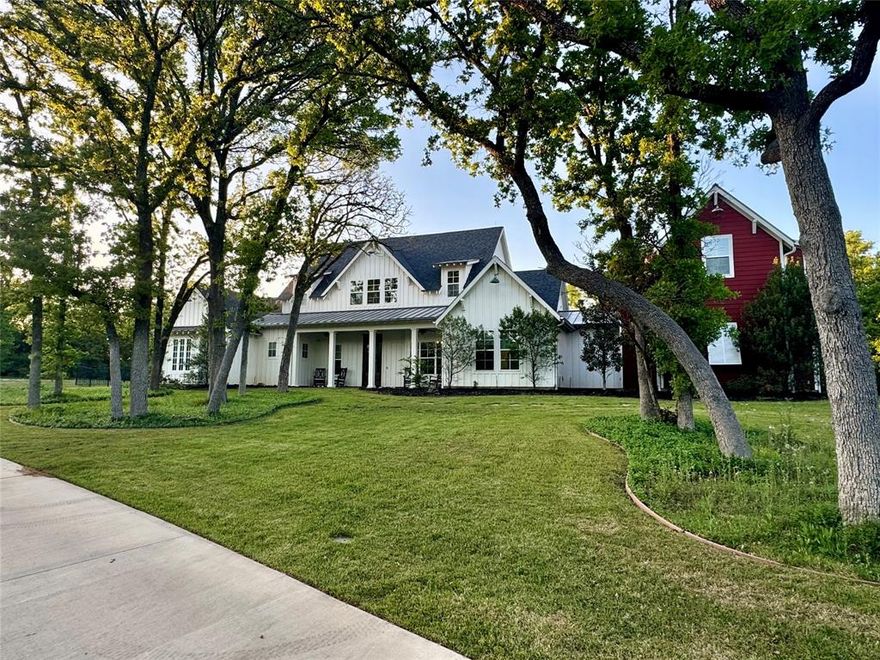 Welcome to 901 Thornridge Circle, a charming Southern farmhouse nestled in the heart of Argyle, Texas. Built in 2017 by Estates by Design Inc.—a highly regarded custom home builder with over 20 years of experience—this thoughtfully crafted home blends comfort and functionality. Set back from the street, this home sits on a beautiful 2+ acre lot, with mature trees, circle drive and cozy front porch. From the moment you step inside, you’ll notice the rich hardwood flooring that flows throughout both the main house and separate guest quarters, setting the tone for the elevated finishes and attention to detail that define this home. The layout features two bedrooms on the main level, including a serene primary suite, and two bedrooms upstairs, each with its own ensuite bathroom. A spacious game room with built-in shelving and a private balcony provides the perfect retreat for play or relaxation. Ideal for guests or multi-generational living, the private apartment above the garage includes a separate entrance, kitchenette, bathroom, living space, and bedroom—all enhanced with hardwood floors for a seamless, quality feel. Working from home is a pleasure in the custom office, complete with built-in shelving and beautiful woodwork that adds both charm and functionality.
At the heart of the home, the gourmet kitchen is a true showstopper, offering two farmhouse sinks, a large island with seating, an oversized walk-in pantry, and top-tier finishes that elevate everyday living. The space flows effortlessly into the main living area, extending outdoors to a large covered patio featuring a fireplace and porch swing—perfect for enjoying Texas sunsets. Designed with comfort and efficiency in mind, this home includes a whole-home surge protector, re-circulating hot water system for instant hot water, and modern energy-saving features. Located in the highly sought-after Argyle ISD, close to dining, shopping, and entertainment.