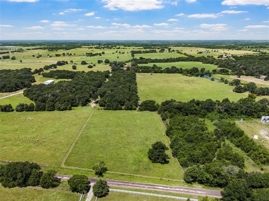 Discover peaceful country living on this ideal 7-acre tract that combines a spacious open homesite that transitions into a heavily wooded section towards the back of the property. The front 3 acres feature a cleared, level pasture measuring approximately 300 ft wide by 400 ft deep that offers a perfect canvas for building your dream home. The remaining 4 acres stretch another 1,000 ft deep and expand over 180 ft in width. This area is heavily wooded with oak trees and various other hardwoods, offering privacy and a natural haven for local wildlife. Enjoy the serenity of nature with quiet surroundings, plenty of room to roam, and no restrictions on how you can make it your own. Currently AG Exempt and located in Mexia ISD. Water available at the road serviced by Point Enterprise. Electric is at the road and available per Navasota Valley Electric. Trash service available. In addition, the adjoining ranch is available as well. Just minutes to Mexia where you will find restaurants, grocery stores and various retail stores. Approximately 48 miles to Waco, 36 miles to Corsicana with DFW being about an hour and 30 minutes away.