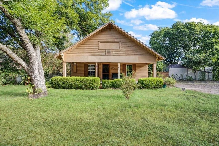 This traditional 1920's frame home has a lot to offer. Great location in Trenton, TX. This is a double lot of almost half an acre and fronts two streets. The back of the lot fronts May Street and has a large metal garage or workshop facing the street, with a brick pathway leading the way from the garage to the home. The backyard has many trees and two storage buildings and wood fencing. The home offers 3 bedrooms, 1 full bath with tub shower combo, a large country eat-in kitchen, a large living room and a cozy but spacious den with a big stone wood-burning fireplace. There is very real potential to easily convert this home into a 2 bed, 2 bath, or 3 bed, 2 bath just by repurposing existing space. Enjoy the fall days on the full length covered front porch.