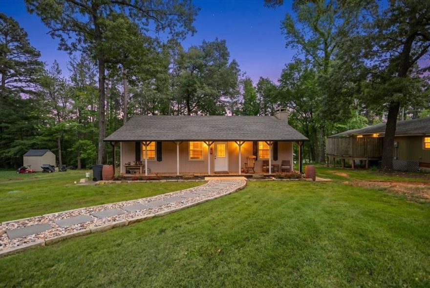 Welcome to your enchanting East Texas retreat, where this charming cottage is in a setting that feels like a permanentvacation. This delightful two bedroom, two bathroom gem has been thoughtfully updated to deliver a lifestyle that perfectly balances comfort and elegance. Step inside and discover an open floor plan adorned with beautiful vinyl plank flooring that flows seamlessly throughout the living spaces. The fireplace serves as a captivating centerpiece, promising warmth andambiance when cooler evenings eventually return though for now, the breezy summer nights steal the show. The kitchen boasts stunning quartz countertops and a breakfast bar that transforms morning coffee into an occasion worth savoring. Both primary bedrooms offer generous proportions and private bathrooms, ensuring that every occupant enjoys their own personal sanctuary. The versatile sunroom is a chameleon of a space equally suited as a formal dining area, asophisticated home office, or a cozy den where weekend naps become an art form. Outside, the magic continues. A brand new back porch overlooks a beautifully treed lot that provides a canopy of shade and privacy an absolute blessing duringthose long, sun drenched afternoons. The detached carport features a dedicated workshop area, perfect for the hobbyist or tinkerer who needs room to create. And for those who fancy themselves anglers of distinction, the best fishing spot on the lake awaits just a leisurely stroll away. Opportunities this charming rarely present themselves in such an idyllic setting. Schedule your private showing today and prepare to be irrevocably captivated.