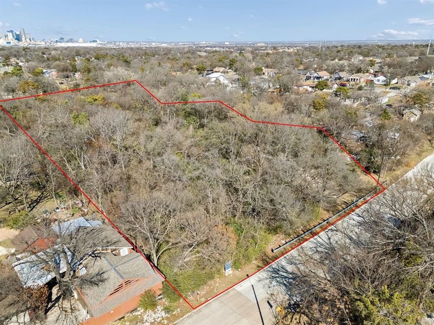 Some properties are measured in square feet. Others are measured in possibility. Spanning approximately 1.288 acres in an established Dallas neighborhood, Stella Avenue offers a canvas unlike anything else currently available in its immediate surroundings. Heavily treed and richly textured, the land feels layered and organic, an untouched pocket of nature within reach of the skyline. A natural creek meanders through the property, adding depth and distinction. Mature trees create a sense of seclusion and permanence, offering both shade and architectural drama for a future build. Whether envisioned as a private estate, a modern sanctuary tucked into the canopy, or a thoughtfully designed investment opportunity, the scale and setting support something truly special. Aerial views reveal what makes this parcel so compelling: proximity to downtown Dallas without sacrificing space. The skyline sits in the distance, a reminder that urban energy is close at hand, while the property itself remains quiet and grounded. With over an acre to work with, there is freedom here: to position a home for privacy, to create expansive outdoor living, to design with intention around the natural topography. The creek corridor and mature trees provide a built-in backdrop that would take decades to recreate. Land of this size, character, and location is increasingly difficult to find. For those ready to build with vision, Stella Avenue presents an uncommon opportunity to shape something enduring in the heart of Dallas.