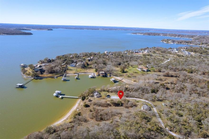 Probably the last 'Valuable Hidden Treasure' of Eagle Mountain Lake waterfront acreage available! This property has been owned by the same family for 66 years. With 2 very functional older cabins (1,100 square feet - 2 bedrooms, 1 bath & 800 square feet - 2 bedrooms, 1 bath). Note: the property info combines the two cabins. Including almost 17 acres, with nearly 1,100 feet of water frontage (the average frontage on EML is 100 feet), on deep water (the dock has 14 feet of water depth when the lake is full). A private entrance makes this property rarely seen by anyone unless you are boating by the property. Let the pictures describe the full benefit. Ask about development potential or just leave it as a very private EML family and friends Estate Escape! Located less than 5 minutes by boat or car to the nationally famous Fort Worth Boat Club. All other lake amenities are a very close boat ride away. The *location on the lake, *privacy, and *view of the lake make this a rare Eagle Mountain Lake *trifecta that 'Is as Sweet as Tupelo Honey'. Come visit and Explore for Additional Benefits Hidden in Plain sight.