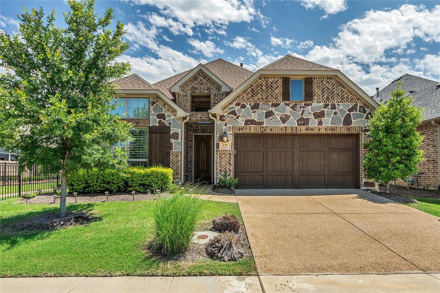 Striking stone and brick front elevation on this 1-story 3 bedroom, 2 bath home draws you on to this premium lot adjacent to community trails and across the street from community fountain. Enter and find wood look floors through most of home with carpet in bedrooms. This is 55+ active adult living at it's finest in the heart of Flower Mound with resort-style pool, fitness center, outdoor catering kitchen, bar, grill & more. Upscale plantation shutters on every window. Kitchen at heart of home with granite counters, stainless steel appliances, massive island-breakfast bar, gas cooktop, an abundance of cabinets, pendant lighting and a walk-in pantry. The grand living area affords plenty of space for large furniture sets and is anchored by an attractive fireplace. Owner's retreat with oversized walk-in shower with tiled walls with accent tile, pebble look floors, granite counters and a walk-in closet that has direct access to the family room. Large covered patio overlooks nice size backyard. 3-car tandem garage for extra parking. What a great place to retire and call home.