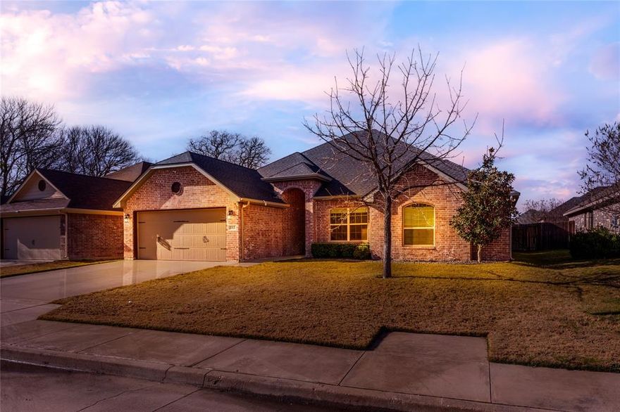 Gorgeous one-owner home, meticulously maintained and located in the highly sought-after Ashley Oaks neighborhood within acclaimed Granbury ISD. This open-concept 4-bedroom home is truly move-in ready, featuring a new roof and gutters (November 2025), wood-look tile throughout the main living areas for easy maintenance, 9-foot ceilings, upgraded crown molding, fresh paint in secondary bedrooms, and a desirable split-bedroom layout. A cozy brick, wood-burning fireplace anchors the living space and adds timeless charm. The chef’s kitchen impresses with custom Knotty Alder cabinetry, stainless steel appliances, granite countertops, a large custom island with outlets and seating, a walk-in pantry, and an oversized deep granite sink—perfect for both everyday living and entertaining. The oversized primary suite offers space for a sitting area and a spa-like ensuite bath with dual vanities, an extra-large tiled shower, and a spacious walk-in closet. Step outside to enjoy the large backyard with covered patio, raised garden beds, full sprinkler system, and plenty of room to relax or play. Ideally located near H-E-B on the north side of Granbury, this home offers convenient access to shopping, dining, and amenities, while still being an easy commute to Fort Worth. This home truly has it all—schedule your showing today!