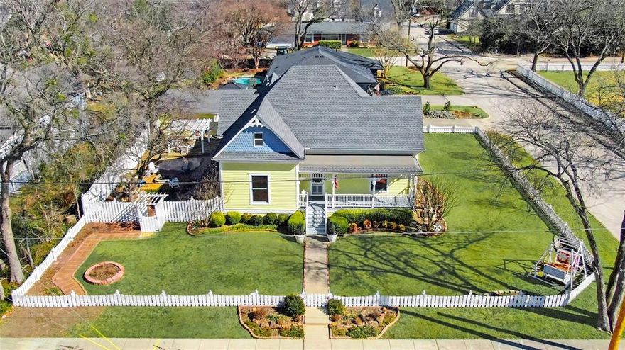 HISTORIC MCKINNEY! This lovely Victorian home sits on a corner lot framed by a classic white picket fence in the heart of Historic Downtown McKinney. Featuring four bedrooms and 2.5 baths, the home beautifully combines historic charm with updates. High ceilings, original wood floors, and natural light fill the interior, creating a welcoming feel throughout. The property also includes a detached two-car garage with a dedicated work area.

The primary bedroom is conveniently located on the first floor with ensuite bathroom, second bedroom and half bath off of the hallway.  First floor features original pine floors and the upper level features original East Texas pine flooring, as well as two bedrooms,  full bath and a versatile loft space. Original boxcar wood countertops in the kitchen add to the home’s authentic historic appeal. Farm sink, refrigerator, pantry space and door leads to back porch off of kitchen for easy access from 2 car garage.  Large driveway with plenty of room for extra parking.

Significant updates include plumbing, electrical, and kitchen improvements, along with a roof replacement approximately three years ago. Outdoor living is enhanced by both front and back porches, a side yard, firepit and a pergola—perfect for relaxing or entertaining!

A rare opportunity to own a beautifully preserved Victorian with modern comforts in one of McKinney’s most sought-after historic neighborhood.

Be sure to see the full UPDATE LIST located in MLS documents.