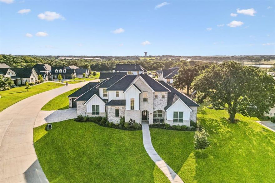 Welcome to luxury living in the heart of Flower Mound’s exclusive Hillside neighborhood. This like-new, East facing, custom-built 5-bedroom, 4.5-bath home sits on an expansive .69-acre corner cul-de-sac lot, offering rare space and privacy in a prime location. Perfect for multi-generational living. Vacant and move-in ready!

Step inside to discover soaring ceilings, exposed wooden beams, and floor-to-ceiling windows that flood the home with natural light. Every detail was thoughtfully designed—from the extensive hardwood floors and plantation shutters to the upgraded lighting, hardware, and stone fireplace. The open-concept living area flows seamlessly into a gourmet kitchen featuring a built-in oversized refrigerator, gas cooktop, and breakfast bar—perfect for both entertaining and everyday living.

The main level offers three spacious bedrooms, each with its own private ensuite, including a serene primary suite and a secondary suite ideal for guests or extended family. Upstairs, you’ll find a versatile game room and two additional bedrooms with a shared bath—perfect for teens, guests, or a home office.

The highlight of this home is the private full-size apartment, complete with its own garage, full gourmet kitchen, living area, and ensuite bath—perfect for a mother-in-law suite, live in nanny, or adult children. With the rising cost of housing, this thoughtful design offers incredible value. Two complete living spaces under one roof, ideal for families with aging parents or college-aged children seeking independence while staying close to home. It’s like getting two houses for the price of one—without compromising on luxury or location.

Outdoors, enjoy a large covered patio with a stone fireplace overlooking a massive backyard. 

Located in a top-rated school district, this home blends luxury, functionality, and convenience.