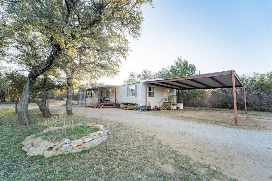 Set on 2 peaceful acres and tucked into a peaceful spot with minimal traffic, this 3 bedroom, 2 bath manufactured home offering 1,232 sq ft of living space combines privacy with convenience. Located just 5 miles from downtown, it provides quick access to shopping, dining, and everyday essentials while still giving you room to spread out and enjoy the land. The home offers a practical, comfortable layout with a primary bedroom featuring an ensuite and two additional bedrooms that work well for guests, family, or office space. The living room stands out with its large windows, filling the space with natural light and giving the room an open, inviting feel. The kitchen and dining area provide a functional setup with plenty of room for everyday use. A metal-covered deck just off the living area creates an easy transition to outdoor living and adds a generous space for relaxing or entertaining. The property includes a storage shed and a perimeter fence, offering flexibility for pets, equipment, or outdoor projects. With 2 acres to work with, there’s plenty of room for gardening, hobbies, or simply enjoying the open space. The surrounding area offers a peaceful setting with the convenience of being close to town, giving you the quiet of the country while keeping everyday needs within easy reach. Buyer or buyer's agent to verify all information.