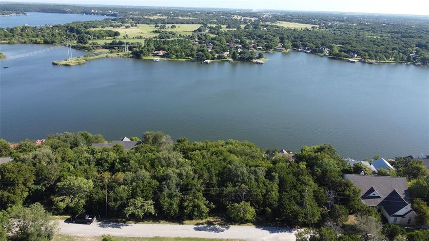 Unmatched Lake Views & Build-Ready Lot in Gated Canyon Creek! Prepare to be captivated by breathtaking panoramic views of Lake Granbury, framed by majestic hardwood Live Oak trees that offer both beauty and shade. This rare offering includes two spacious lots sold together, providing an abundance of room to build your custom dream home with privacy and flexibility. Perched high on a bluff, this property delivers a true “wow” factor—offering unobstructed, elevated lake vistas that stretch for miles. The property line extends all the way to Rock Ridge Drive, guaranteeing that your views will remain protected and unspoiled for years to come. location on a quiet street in gated Canyon Creek subdivision. The impressive neighborhood amenities include 2 boat ramps, fishing pier, baseball park, basketball courts, clubhouse, park & picnic areas, kids playgrounds, RV park spaces, sandy beach area, 2 swimming pools, Tennis Courts, and 24 hour on-site security. With gentle topography for easy construction, these lots offer the perfect canvas for your lakeview retreat. Whether you’re ready to build now or invest in your future, don’t miss the chance to own a slice of paradise with million-dollar views at a fraction of the cost.