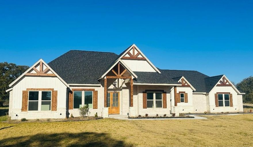 Beautiful Custom Home, Brock ISD in Upscale Gated Community: 4-bedroom, 3.5-bath estate offers 3,331 square feet of luxury living, thoughtfully designed for style, comfort, and function. Split bedroom floorplan with his...her area custom closet design, separate vanities. Don't forget to check out the 2 extra walk in closets for storage. One is in the hallway between two bedrooms, and one is in the main bathroom. But don't worry, you still have amazing closets in the bedrooms. Pantry designed for the person who loves to cook. Kitchen has a Double oven, gas cooktop, farm sink, trash cabinet, utensil drawer, but best of all the bottom cabinets. No more digging for the item in the back of the cabinet, as these shelves all pull out. Property Features: Vaulted Ceilings which enhance the open and elegant atmosphere, White Oak-Stained Kitchen Cabinets, gas fireplace, Custom Lighting throughout, Study with Designer Touches offering a serene space for work or creativity. Game Room ready for fun, media, or hobbies. 3-Car Garage featuring a Dog Wash Station—a rare perk for pet lovers. Our garage doors are insulated, and openers have a camera system and remote access from your phone. This home on 1 acre, but other acreage lots can be purchased, comes with water tap. 2 acres of water rights available for purchase for future well. Two sources of water is an amazing and unique feature in Brock. Come home to the country in this beautiful home.