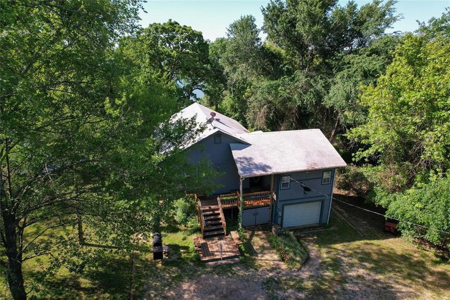 Looking for a cabin in the woods getaway? This waterfront secluded home sits in a lovely subdivision on a large open cove. If you want a woodsy, natural surrounding with elbow room and privacy, this is it! You enter on the second story which has an open living design with kitchen and living opening out onto a screened patio with elevated views across the water. There is an office area off of the kitchen that could be used for a small set of bunk beds.  Home has two master suites, one up and one down with both stairs and an elevator. The lower level has a second living area complete with pellet stove that heats the whole home in the winter and gives the coziest feel! Oversized laundry and storage room perfect to store all the life vest and float toys! Fenced yard out back is ready for family pets. Well established lawns and mature trees surround this lovely lake cabin. VRBO and short-term rental is allowed. Perfect cove for kayaking, paddle boards and boating fun!