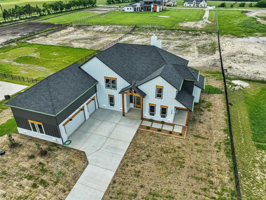 This luxurious new construction home in Gunter, Texas offers modern living, premium craftsmanship, and the rare advantage of a full one-acre lot. As you walk in, the grand chandelier & very high ceilings create an immediate sense of elegance & openness. Large windows throughout the home maximize natural light & bring a bright, inviting atmosphere into every room. The open concept design seamlessly connects the breakfast area, dining room, and spacious living room, making it ideal for everyday living and entertaining. The chef-inspired kitchen features a 48-inch professional gas cooktop, pot filler, double ovens, quartz countertops, and a farmhouse sink, highly sought-after amenities that add strong value and appeal. Every bedroom is an ensuite with its own private bathroom, offering comfort and privacy for guests or family. The primary suite was designed as a true retreat, with a spa style bathroom that includes a Roman shower, freestanding soaking tub and a large custom closet with built in drawers and a center island. The home also features a dedicated media room with a built in bar & refrigerator ready space, perfect for movie nights or entertaining. Additional conveniences include a private office with exterior access and extra storage closet around the media room. Outdoor living is exceptional with 800+ sq. ft. covered patio, 20 foot ceilings, a fireplace, and a gas line ready for your grill, perfect for gatherings or peaceful evenings at home. The three-car garage offers an EV charging station, a rear access door to the backyard, and dedicated wine storage.  Its location near Preston Road and Highway 75 provides excellent access to Frisco, Celina, Prosper and the entire North Dallas corridor. This property is a rare opportunity for buyers searching for a luxury home on a one acre lot with high end finishes, open concept living, a chef level kitchen, a spa inspired primary suite and exceptional outdoor living in one of the fastest growing areas of North Texas.