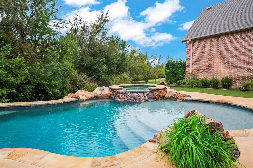 HUGE PRICE REDUCTION. This is a GREAT price on this stunner! House was recently repainted and refreshed. Escape the hustle of the metroplex to reside in this 4000 Sq Ft custom home located in the sought-after Hackberry Heights. The house is move-in ready and GORGEOUS! 1-acre lot with a heavy tree line which provides for a private backyard.  5G Fiber internet is a bonus!  No City Taxes NO MUD NO HOA. Tax rate $1.67
The beautiful timeless front exterior showcases a gorgeous blend of brick, stone, and cedar finishes, and beautiful landscaping.
Inside the home, this thoughtful floor plan includes four bedrooms downstairs, along with a guest suite upstairs with a full bath. The flexible floor plans has 2 offices or craft room with built-ins. The Primary Suite is 23 x 15. The floor-to-ceiling windows have a view of the pool and trees in the backyard. The ensuite bath has double vanities and dual closets with built-in dressers. The living, dining, kitchen, and work areas downstairs have hand-scraped hardwood flooring. All of the carpet in the house was replaced in May of 2025. The spacious kitchen, with 2 sinks, lots of storage, and counter space, is a great place to cook and entertain. The kitchen has a gas cook-top, a large breakfast bar, beautiful custom cabinetry and hood. The walk-in pantry has room for everything!

The backyard has features for all seasons. The pool and spa, built by the renowned Allison Pools, is picturesque with a backdrop of mature trees. In the Wintertime, you will enjoy cozying up to the built-in fireplace on the back patio. Your dogs and kids will enjoy the separate fenced-in play yard. This property is more than just a house—it's a private retreat in the country where you can enjoy luxury, space, and serenity every day
 We are looking for a new family to fill this home with love, laughter, and fun.  If you are ready to make beautiful memories and you want to be in the very sought-after, after award-winning VAISD, come tour this beauty.