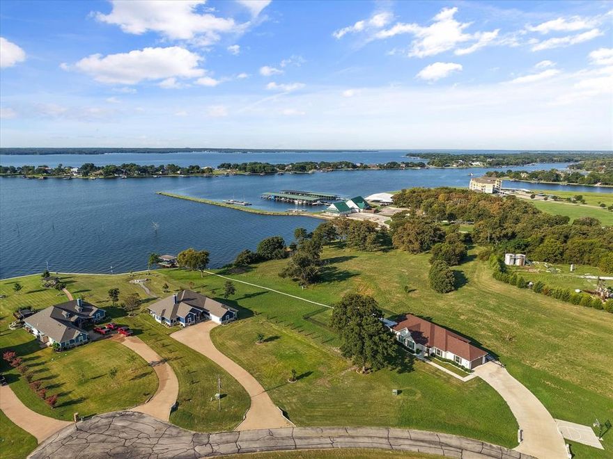 Wake up every morning just steps away from the water. Watch the sun rise each morning with cup of coffee in your rocking chair, and a have a glass of wine at sunset by the waterside firepit or while you wind down in the Michael Phelps Legend Series hot tub. This is what lake life is all about! Tucked into a small, gated community, this custom-built home on over an acre of waterfront property was thoughtfully designed to have water views from almost every room. The heart of this home is the open concept living and dining space with plenty of room for all to gather. This kitchen offers everything a home-chef could desire: beautiful granite countertops with subway tile backsplash; a large oversized island offers plenty of prep, serving, and dining space; double stainless steel ovens; an built-in hutch or coffee bar with floating shelves; and tons of storage space. The comfortable-sized living space is anchored with built-in shelving and stone fireplace with wood beam mantle. The primary suite to the right of the home provides a tranquil space for relaxation with natural light, amazing views of the lake, and a private entry to the back porch; primary en-suite is complete with dual vanities, oversized show, and large walk-in closet. The left side of the home has 2 additional secondary bedrooms with ample closet space, and a large shared bathroom. 4th bedroom in the front of the home is perfect for guest suite or designated office space. This recently built home has luxury plank flooring throughout; oversized laundry room, and designated office space. Oversized garage has small bay door opposite the main bay for easy access to lawn care or lake items. This prime waterfront location is within walking distance to the local marina, and provides a front-row seat for the holiday boat parade and fireworks show!!